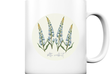 Weiße Tasse mit einer Illustration von Glockenblumen und dem Text „petite rebelle“.