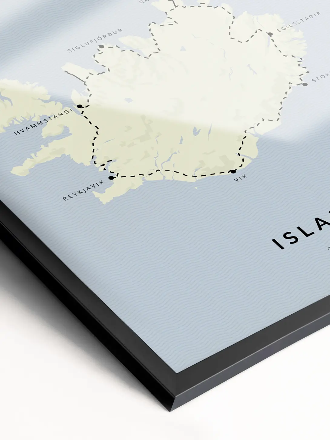 Nahaufnahme einer Karte, die einen Teil von Island mit beschrifteten Orten wie Reykjavik und Hvammstangi zeigt. Die Karte hat einen hellblauen Meereshintergrund und eine schwarze Umrandung am Rand.